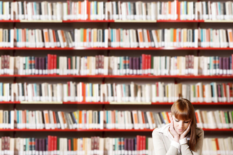 Studerend meisje voor muur met boeken
